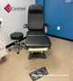 Refurbished MTI 525 with black upholstery, a foot control, and a matching stool in a clinic room.