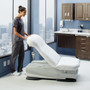 Healthcare worker adjusting Midmark 626 exam chair in a modern clinic room.