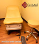Midmark 626 exam chair with white upholstery, foot control, and matching stool in a medical office.