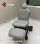 Gray Midmark 630 exam chair with extended footrest and foot control on white flooring.