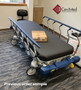 Refurbished Stryker 1004 in the lobby of a medical clinic with black mattress.