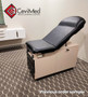 Midmark 104 exam table with black round-top upholstery and beige frame, featured in clinic setup.