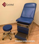 Midmark 104 round top exam table with blue upholstery and a matching stool.