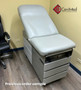 Midmark 104 round top exam table with gray upholstery.