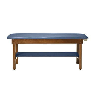 Ritter 95 treatment table with blue upholstered flat top, wooden frame, and integrated lower storage shelf, viewed from the front.