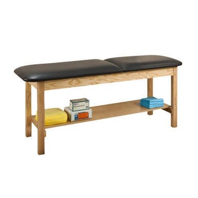 Black cushioned treatment table with natural wood frame and built-in lower storage shelf, stocked with folded towels and medical supply boxes, suitable for clinical or therapy use.
