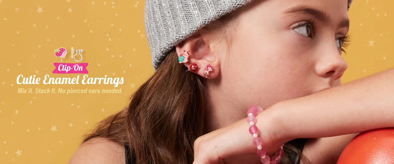 Girl wearing Girl Nation Clip-On Cutie Enamel Earrings in mixed designs
