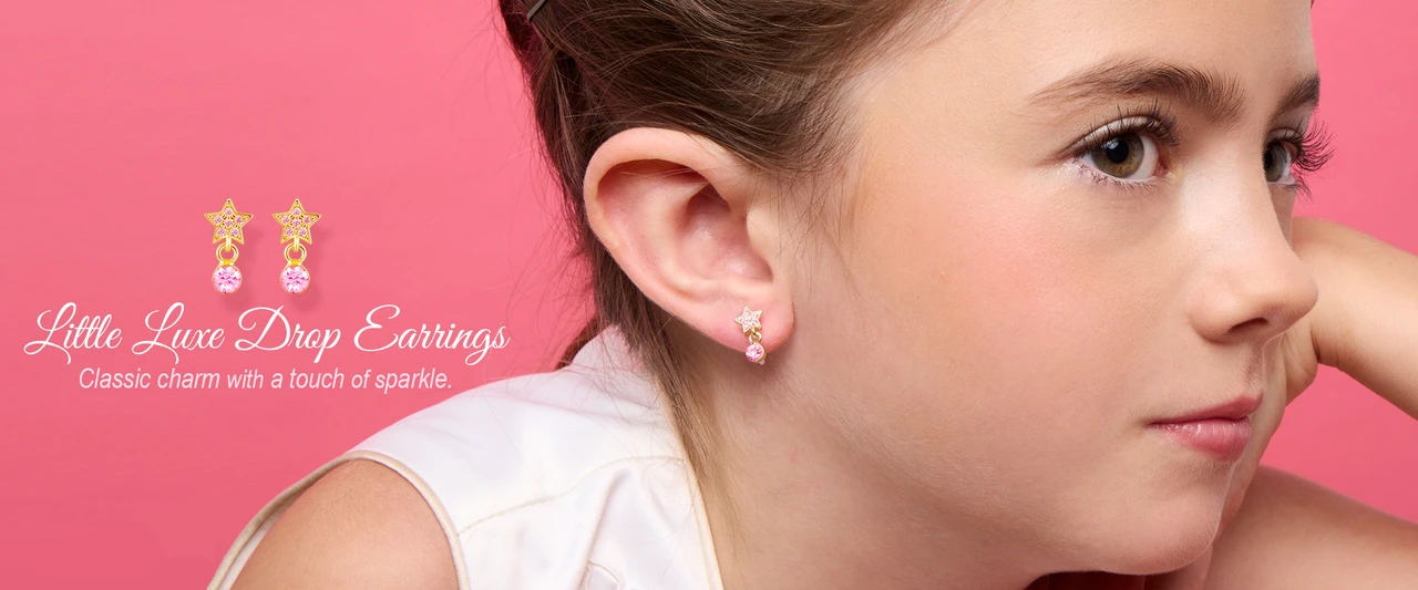 Girl wearing Girl Nation Little Luxe Drop Earrings with pink star and crystal design