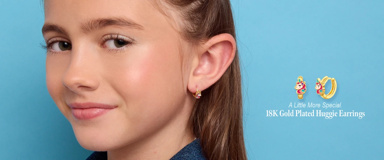Girl wearing Girl Nation 18K gold plated unicorn huggie earrings