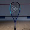 Dunlop FX 125 Pro Lite squash racquet standing upright on a squash court, front view of the strings