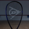 Dunlop FX 115 racquet head on a squash court, front view of the black frame and Dunlop logo strings