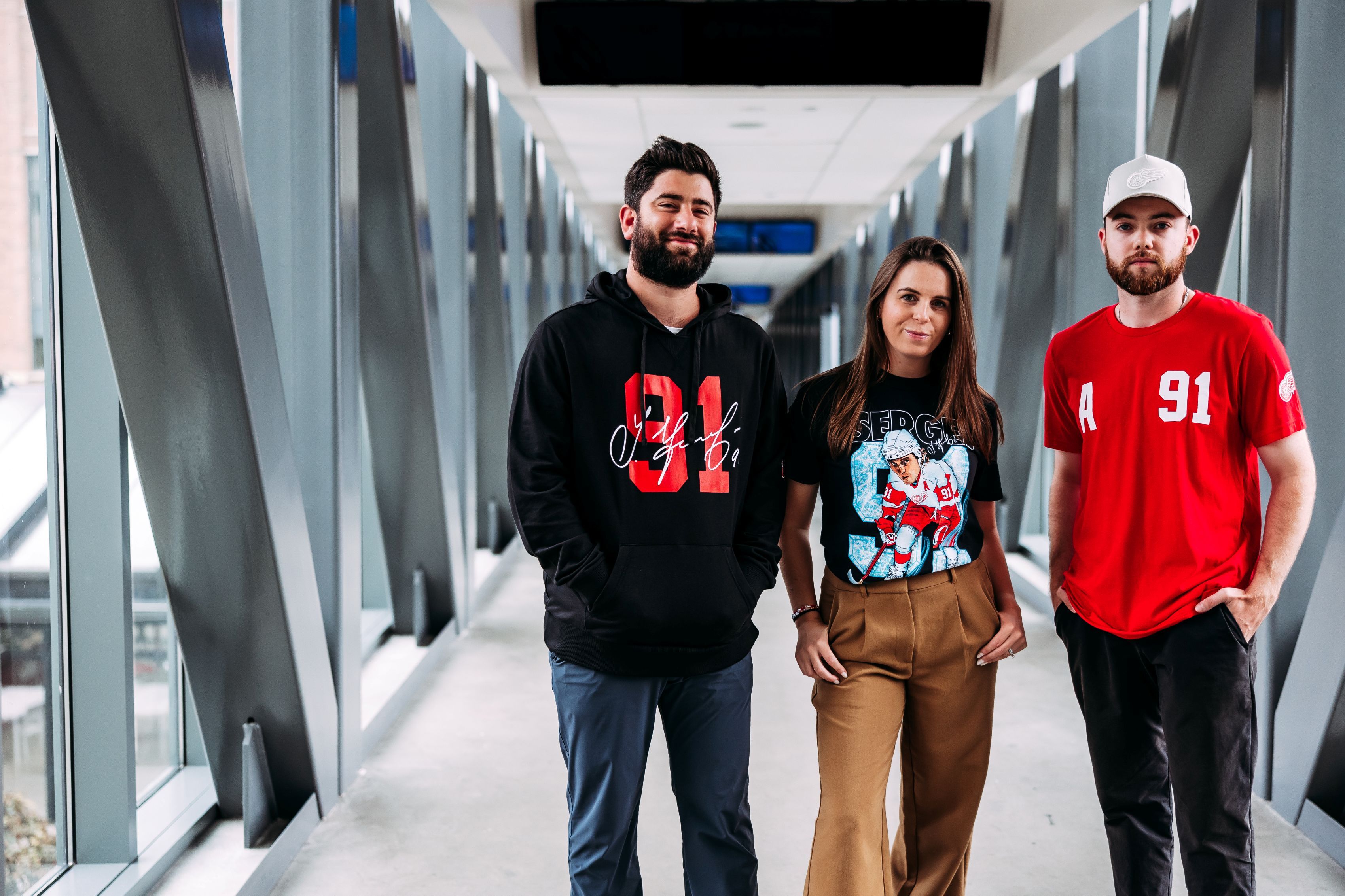 Three adults modeling all three Fedorov Signature apparel items, with a focus on the new Fedorov caricature t-shirt.  data-size=