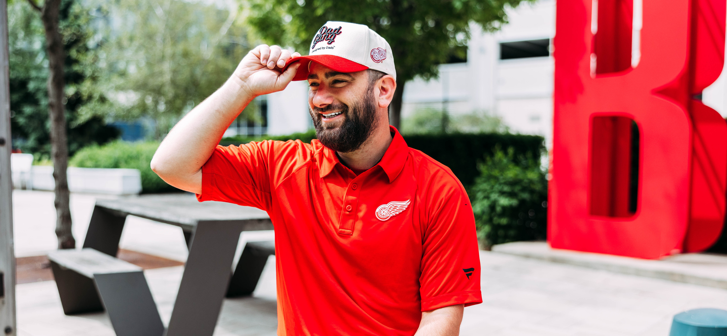 Photo of a young male modeling the exclusive, one time adjustable headwear drop between Detroit Red Wings and DadGang.  data-size=