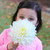 Dinnerplate dahlia Fleurel being held by a young girl to emphasize this pure white flower's large size.