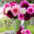 A bouquet of two dozen white, pink and burgundy dinnerplate dahlias in a galvanized bucket, on an outdoor table.
