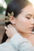 Close-up of the gold Reyna Ear Cuff worn on a model, showcasing its bold right-ear statement design inspired by the Philippine three stars and sun. This detailed product shot highlights the dramatic curves, regal silhouette, and striking Filipina-inspired style of this standout ear cuff.