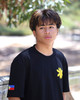 Young Filipino man wearing the Kapwa Legacy Tee at a 45-degree angle, showcasing the raised 3D puff Kapwa Legacy logo on the front and the embroidered Philippine flag patch on the right sleeve. Premium Filipino streetwear T-shirt made from 100% ring-spun cotton with 240 GSM heavyweight pre-shrunk fabric.