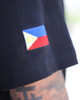 Close-up of the right sleeve of the Kapwa Legacy Tee featuring the embroidered Philippine flag patch on the arm of a tattooed model. Premium Filipino streetwear T-shirt made from 100% ring-spun cotton with 240 GSM heavyweight pre-shrunk fabric and quality embroidered detailing.