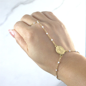 Filipino-inspired White Dasal Hand Rosary Bracelet worn on a hand facing upward, featuring a gold-plated stainless steel rosary chain with finger loop and adjustable wrist sizing.