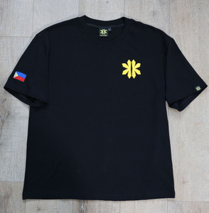 Overhead view of the Kapwa Legacy Tee featuring a raised 3D puff Kapwa logo on the front, woven Kapwa Kultura neck label, size tag inside the collar, custom woven sleeve label on the left sleeve, and embroidered Philippine flag patch on the right sleeve. Premium 100% ring-spun cotton heavyweight Filipino streetwear T-shirt.