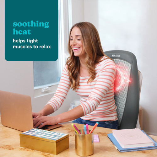 A woman smiles while using the Shiatsu Massage Cushion at her desk, with a red glow on her lower back showing the heat feature.