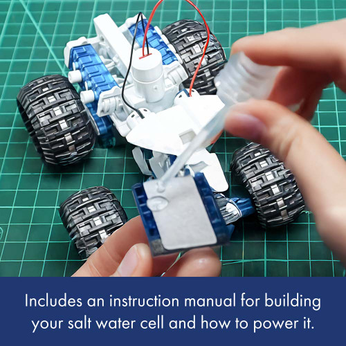 A person carefully adds salt water with a pipette to the fuel cell of the toy engine. Instructions are included inside.
