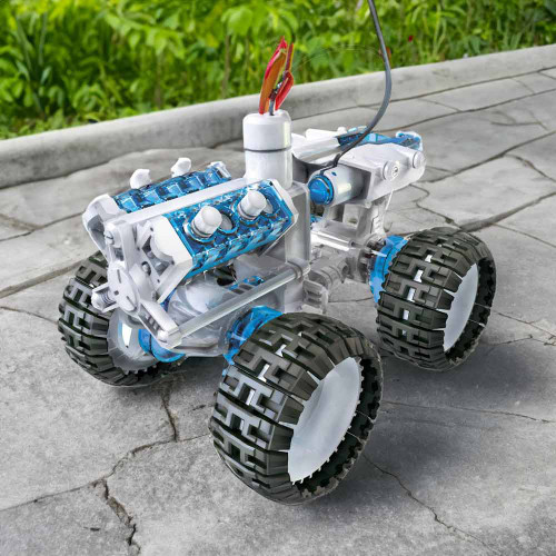 Assembled salt water fuel cell engine car with a clear blue engine and rugged wheels, shown on cracked pavement outdoors.