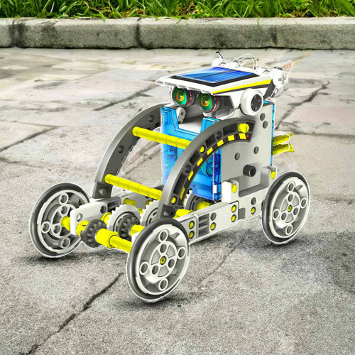 The Solar Robot kit built as a grey and yellow four-wheeled rover with visible gears and a solar panel, outdoors on a paved path.