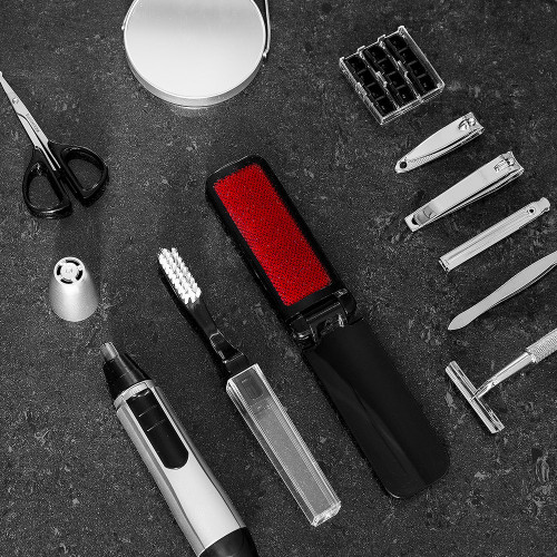 A 10-piece grooming kit displayed on a dark grey surface, showing clippers, a razor, nose trimmer, lint brush, and mirror.
