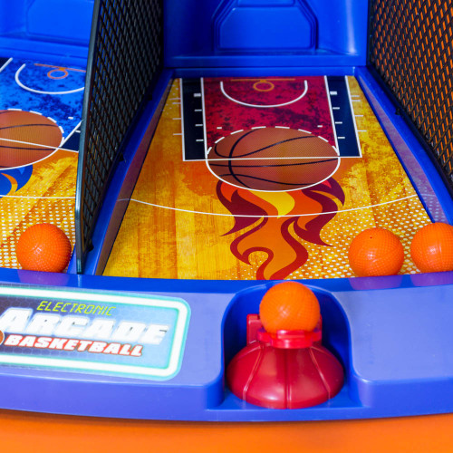 Close-up of the Electronic Arcade Basketball game, showing two side-by-side courts with launchers and mini orange basketballs.