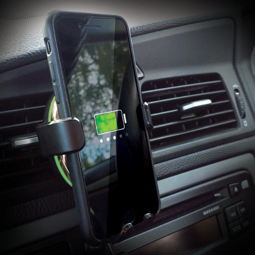 A smartphone held in the InGenious wireless car charger, mounted to a dashboard air vent and showing the battery charging.