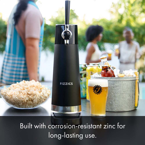 A black countertop draft beer dispenser sits on a table set with snacks, including chips and salsa, while other people stand nearby. The text below details the materials the dispenser is made from.