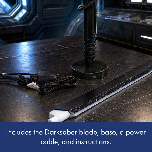 The Darksaber desk light laid out on a table, showing the included hilt on its base, the separate blade, and a power cable.