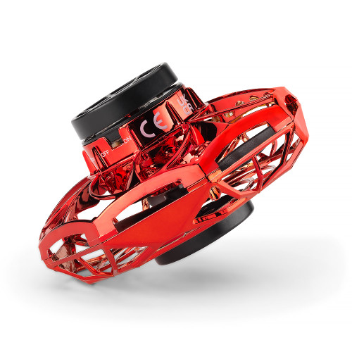 A red metallic Vortex Spinner angled on its side, showing its case and the black centre with an on/off switch.