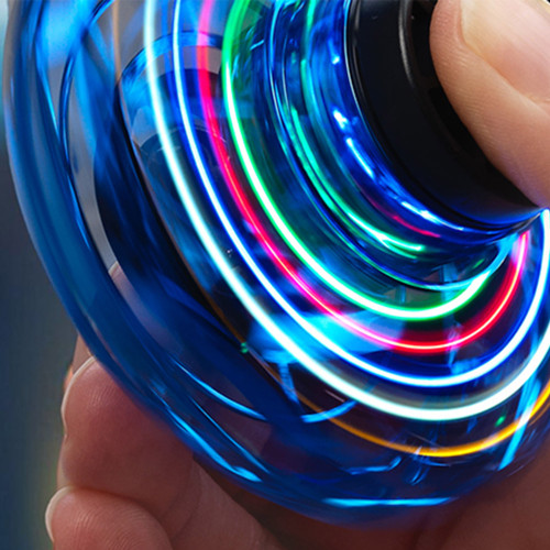Close-up of the blue LED Vortex Spinner creating colourful light trails as it spins rapidly in someone's hand.