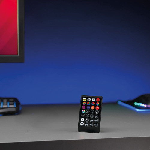The remote control for the sound reactive lights stands on a grey desk, with a blue glow from the backlighting.
