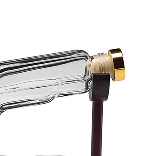 Close-up of the gun decanter's neck and gold-coloured stopper resting securely in the dark wooden stand.