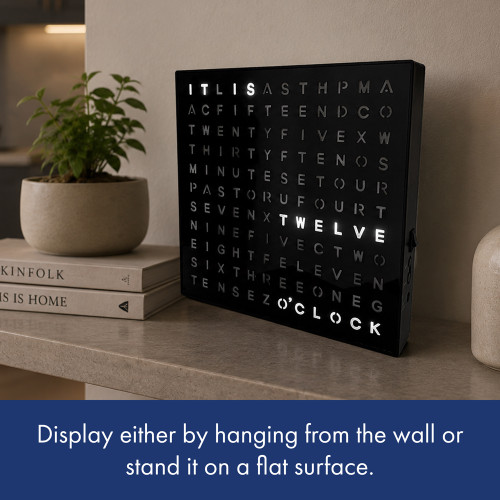 A black word clock. It shows how you can mount it to a wall or display it on a flat surface