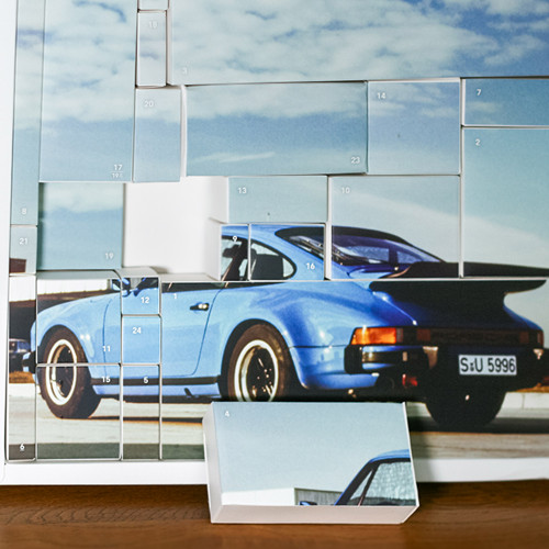 The Porsche 911 Turbo advent calendar on a wooden surface with some boxes open.