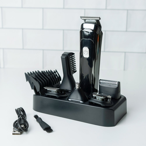 The black InGenious Grooming Kit, with trimmer, heads, and guards, neatly organised in its stand on a white tiled surface.