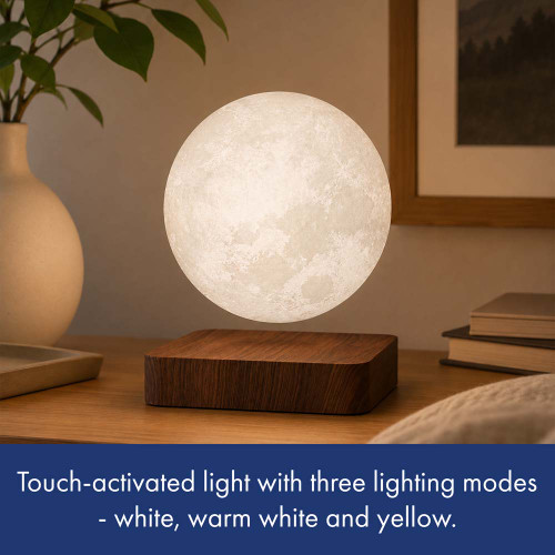 The glowing Floating Moon lamp levitates over its wooden base on a bedside table. Features three touch-activated light modes.
