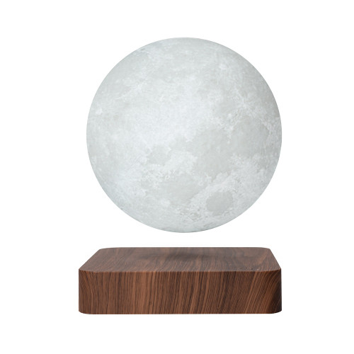A textured, grey moon lamp levitates above a square, dark wood-grain base on a white background.