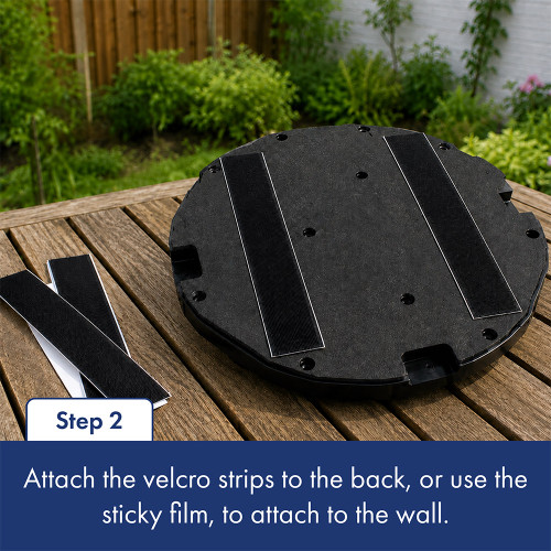 A circular black outdoor boxing pad is turned upside down to show the sticky back with velcro strips. The text below describes step two about attaching the velcro to the back of the pad.