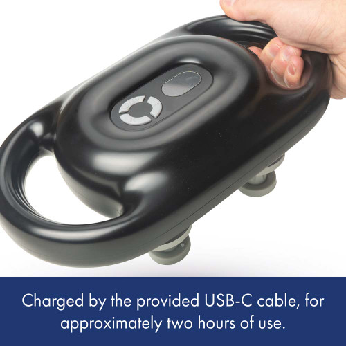 A hand grips the handle of the black Wellbeing 4 Point Percussion Massager, showing the USB C charging port.