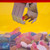 A close-up of the Candy Grabber's claw picking a fizzy sweet from a colourful pile against a yellow background.