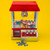A red and silver Candy Grabber filled with colourful sweets. Its claw is poised over the prize and toy coins sit in front.