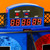 Detail shot of the electronic scoreboard on the arcade basketball game, featuring a red digital display, reset, and on/off buttons.
