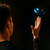 In a dark room, a man watches a blue LED Vortex Spinner hovering above his outstretched hand.