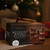 The gift box for Rotating Whisky Glasses sits on a woven mat under a decorated Christmas tree, surrounded by presents.