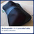 A close-up of the black mini massage cushion on a fabric chair, showing its mesh surface. The cushion is rechargeable.